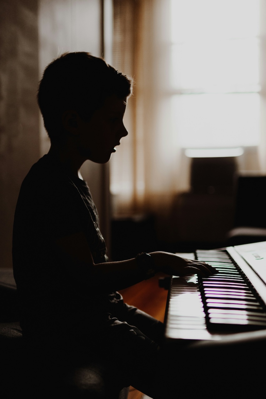 a kid learning how to play piano